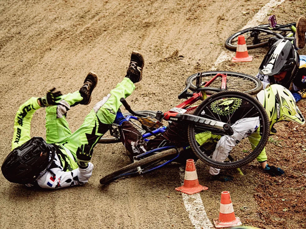 Photo d'une compétition de BMX. Plusieurs vélos sont au sol suite à une chute.