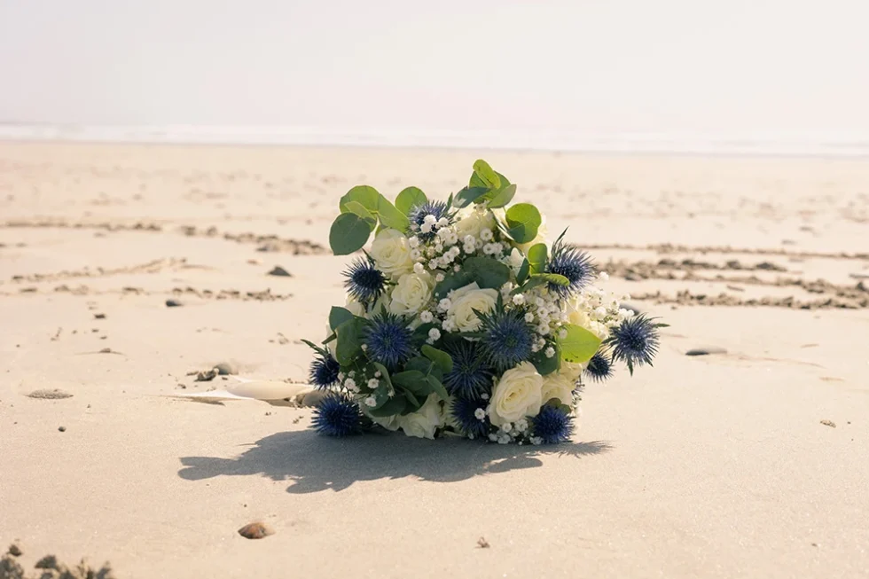 Bouquet de la mariée posé sur le sable