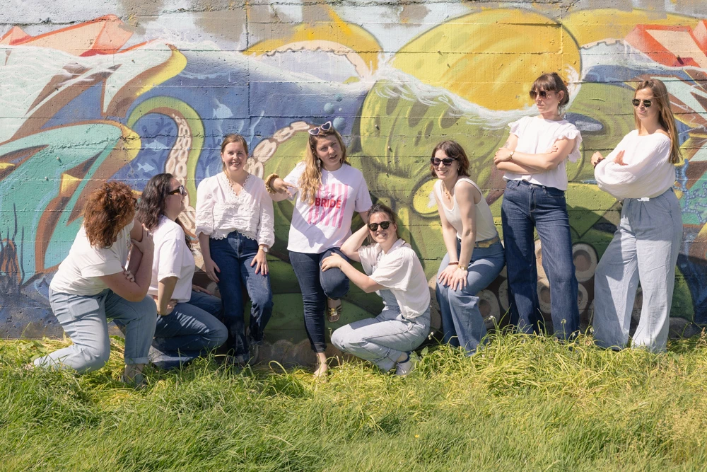 Groupe d'amies réuni devant une fresque colorée lors d'une séance photo d'EVJF.